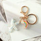 Keychain with star and rainbow charm on a marble surface