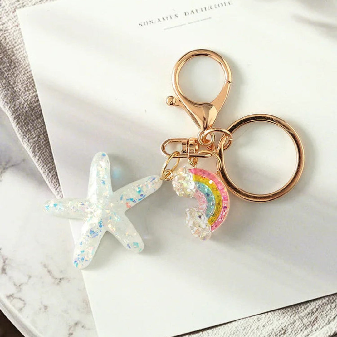 Keychain with star and rainbow charm on a marble surface