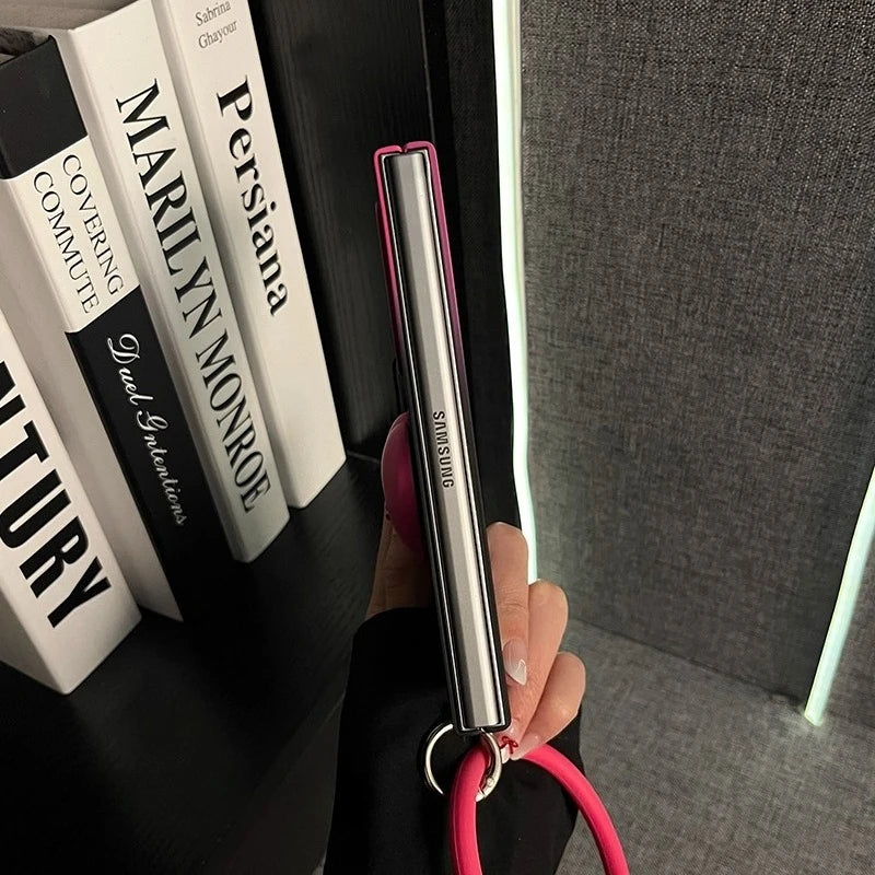 Hand holding a Samsung pen with books in the background