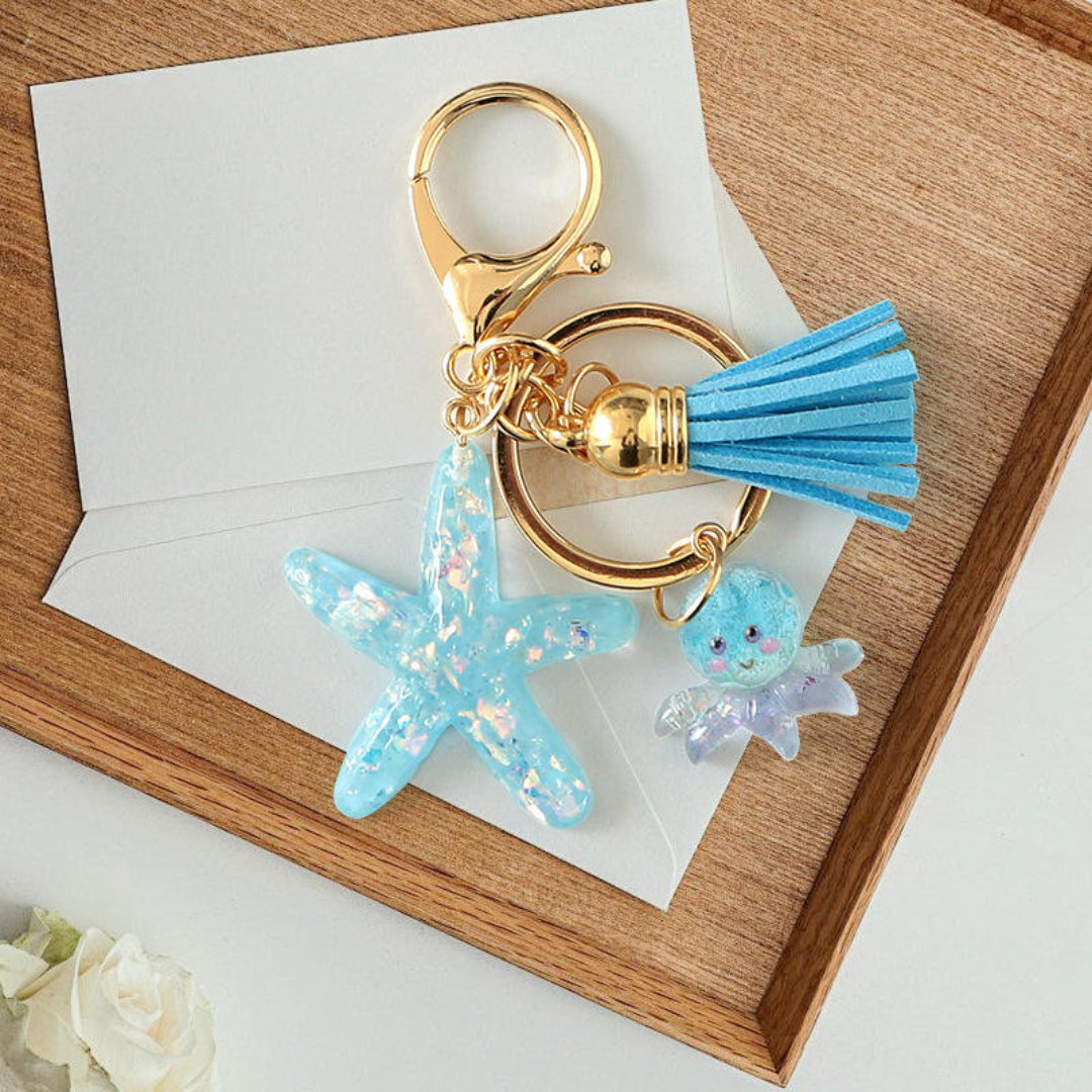 Keychain with blue tassel and starfish charm on a wooden surface