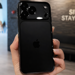 Black smartphone held in a hand with a blurred indoor background